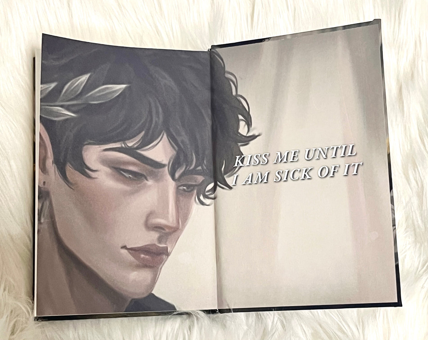 Open book with a black and white illustration of a person's face on one page and text on the other, on a soft white background.