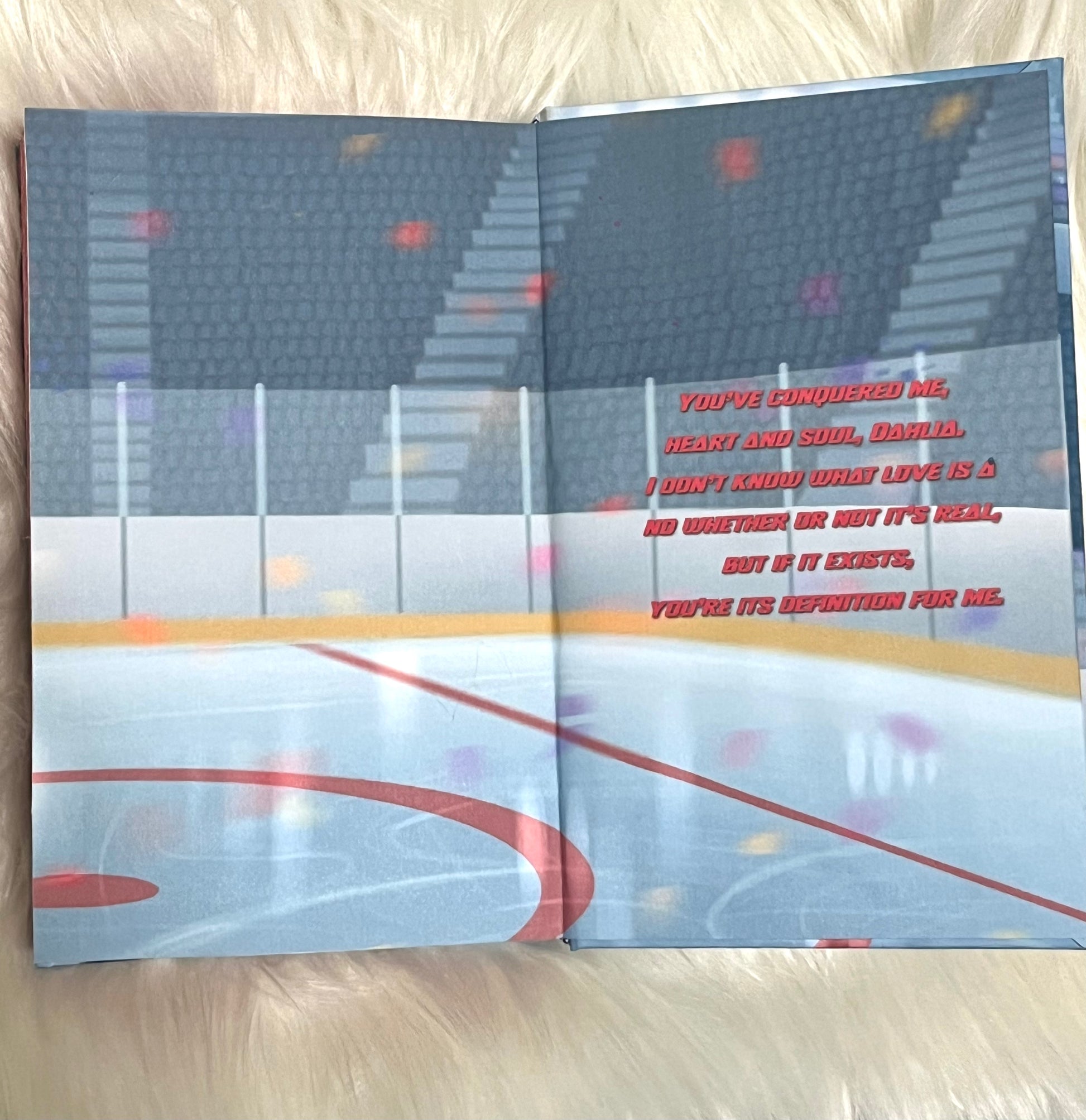 Open book with a sports arena illustration and text on a wooden surface