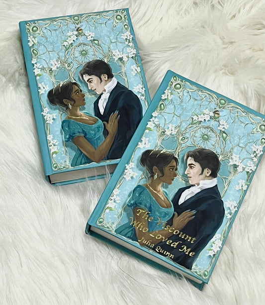 Two books with artistic covers featuring a couple on a white fluffy surface