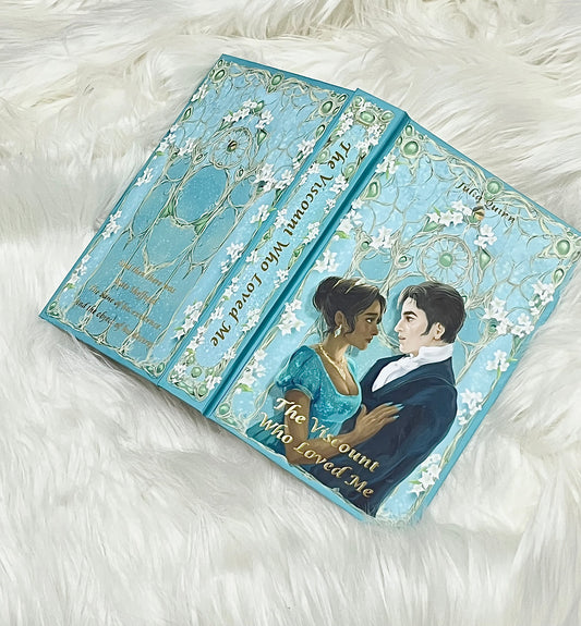 Decorative book with illustrations of a couple and floral designs on a white fluffy surface